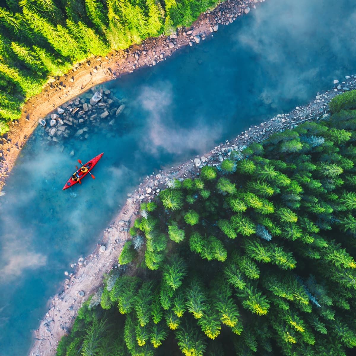 Aerial shot of kayak going through river. 