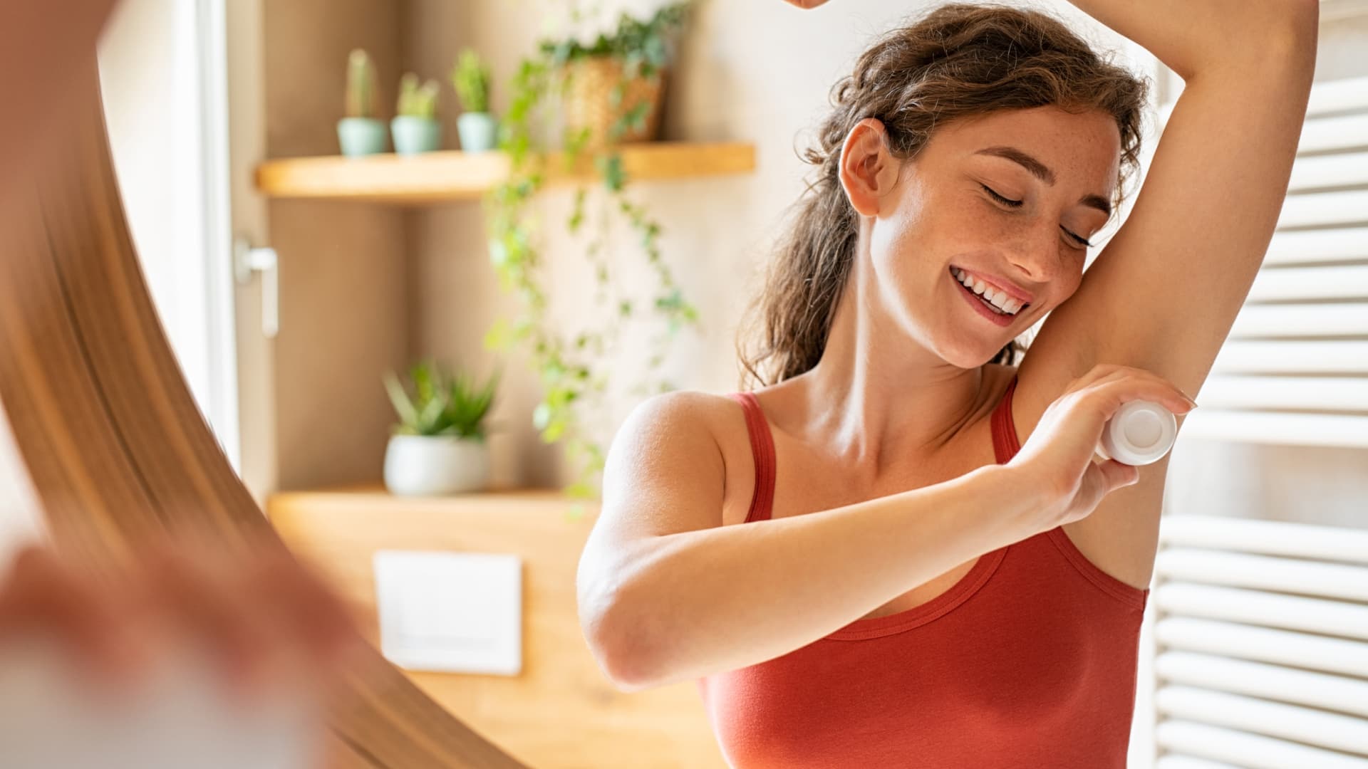 Woman applying underarm deodorant.